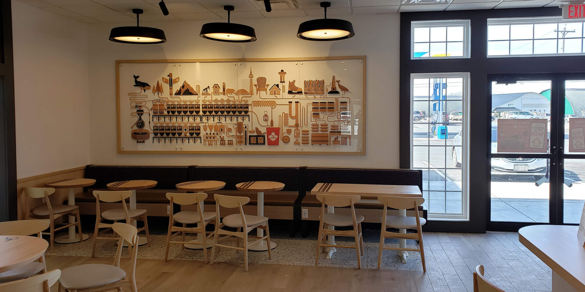 A restaurant with tables and chairs in front of the wall.