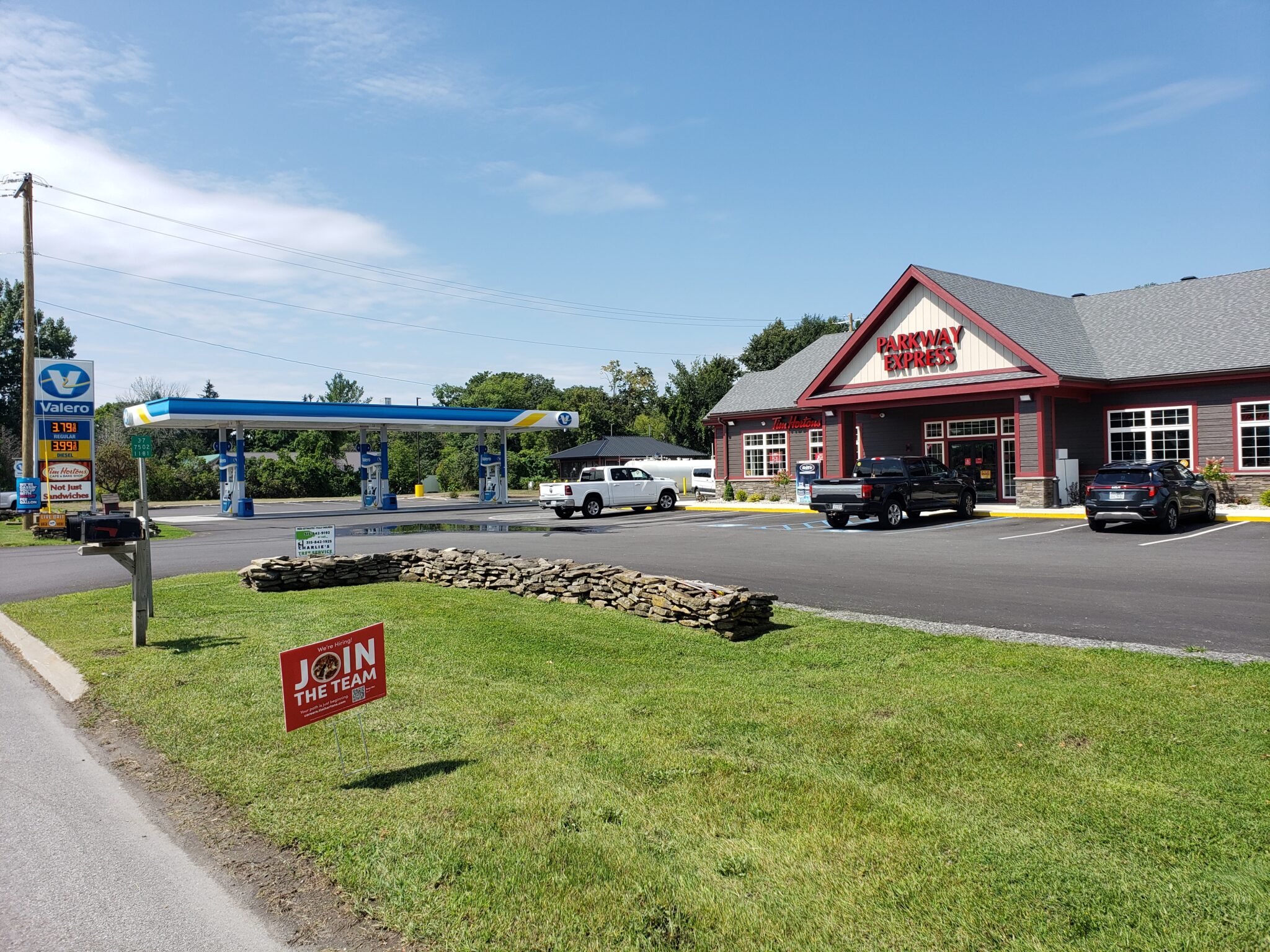 A gas station with cars parked in front of it.