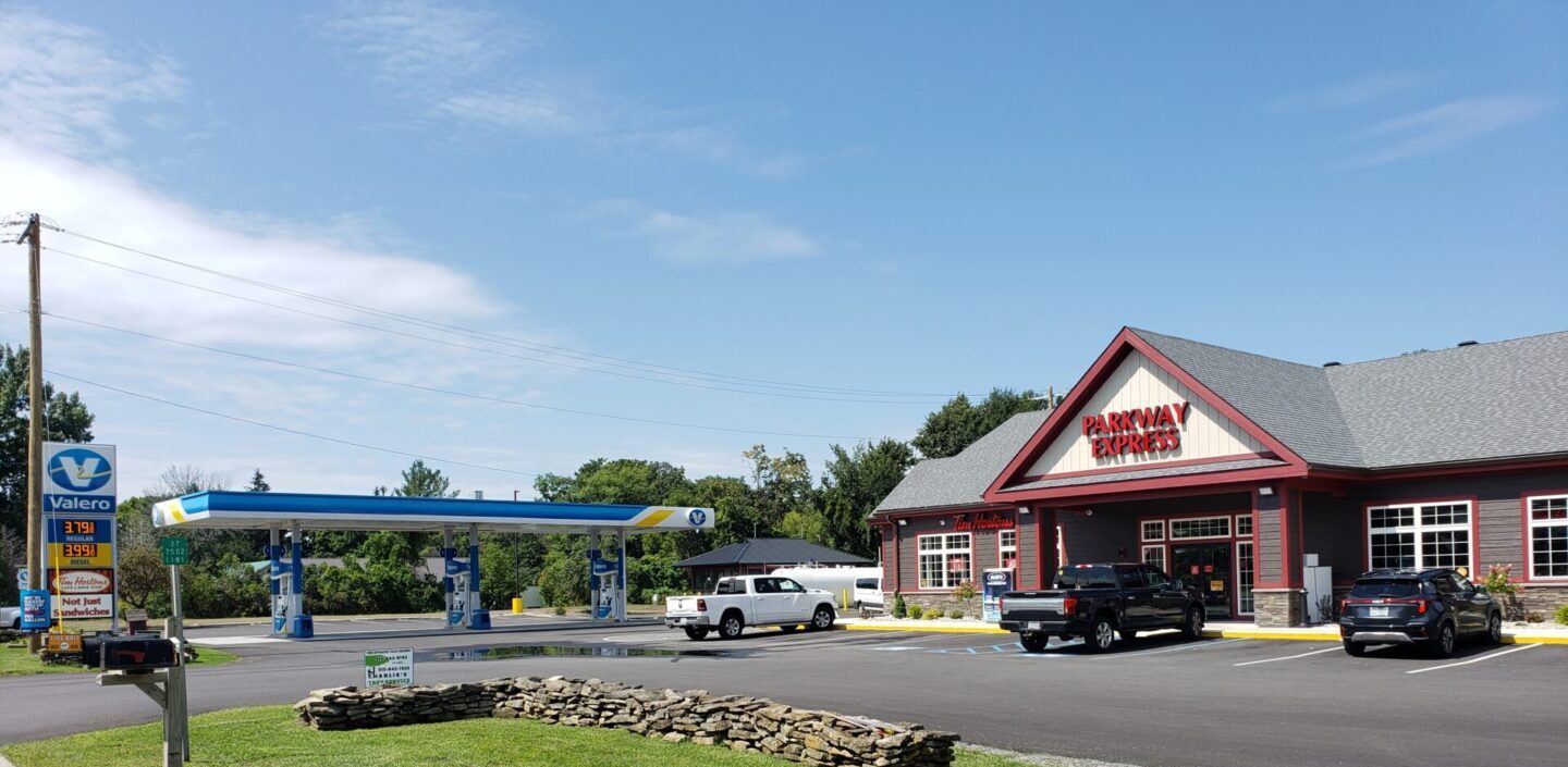 A gas station with cars parked in front of it.