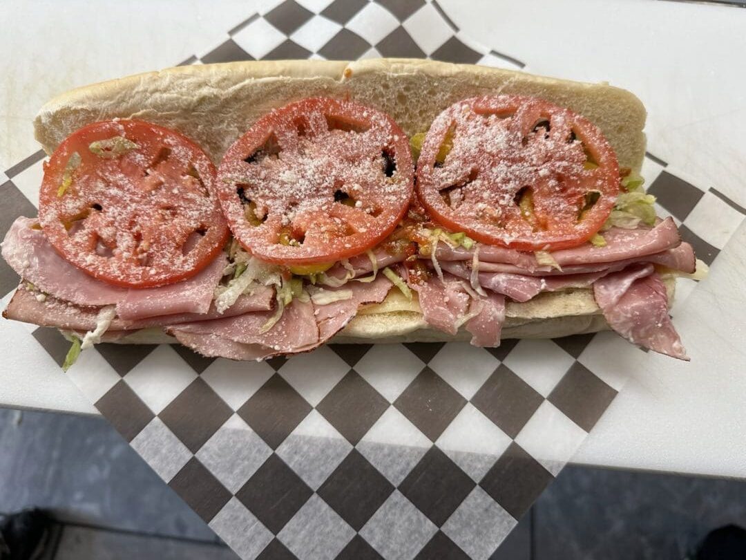 A sandwich with tomatoes and meat on it.